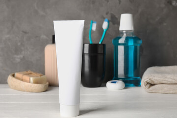Fototapeta na wymiar Toothpaste and bath accessories on white wooden table
