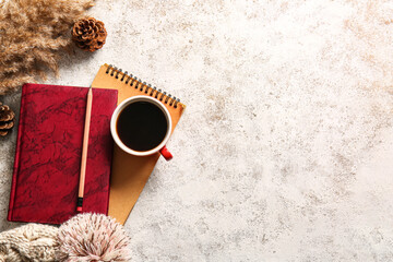 Book, cup of coffee and warm hat on light background