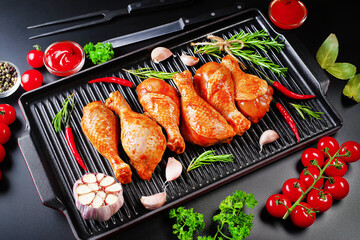Raw marinated meat.Chicken legs in red marinade on a glaze baking pan with various spices.