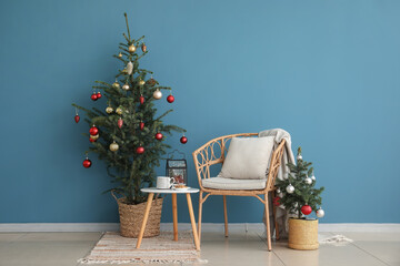 Decorated Christmas trees and armchair in interior of room