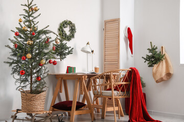 Interior of modern room with Christmas tree and comfortable workplace