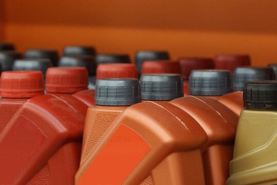 Row Of Brown Red Plastic Bottles Jerry Cans With Black Lids