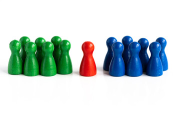 Eine rote Spielfigur in Mitte, zwischen zwei Gruppen von anderen Spielfiguren in blauer und grün