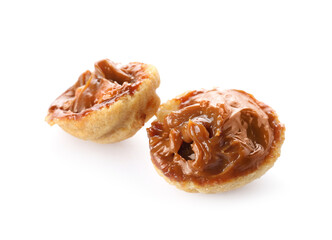 Halves of tasty walnut shaped cookie with boiled condensed milk on white background