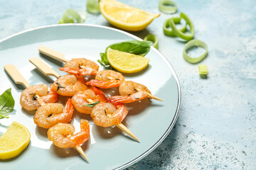 Plate with grilled shrimp skewers on blue background, closeup