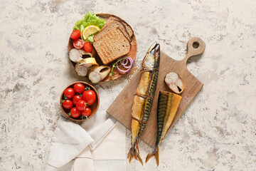 Wooden board with smoked mackerel fishes and bread on beige background