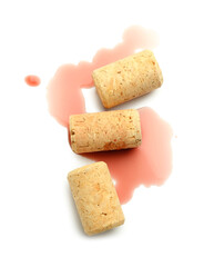 Spilled wine and corks on white background