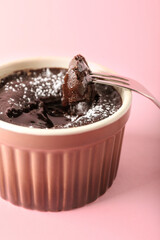 Ramekin with tasty lava cake fondant on pink background, closeup