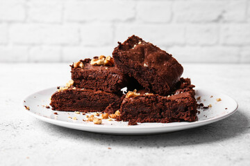 Plate with pieces of tasty chocolate brownie on table