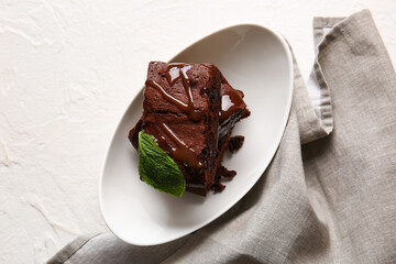 Bowl with pieces of tasty chocolate brownie on white background
