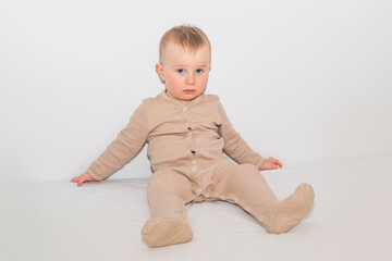 A boy in pajamas sits on a white sheet