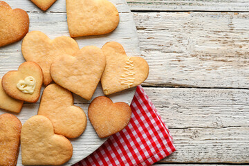 Board with tasty heart shaped cookies on white wooden background, closeup. Valentines Day celebration