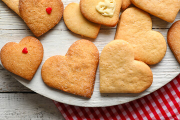 Board with tasty heart shaped cookies on white wooden background, closeup. Valentines Day celebration