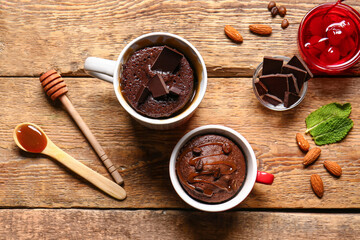 Cups with tasty chocolate brownie on wooden background