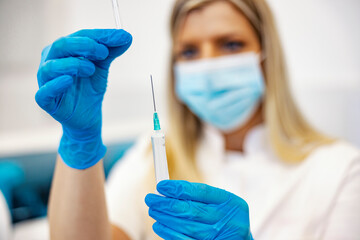 Vaccine, prevention, and immunization. Close up of a nurse in the laboratory holding a syringe and...