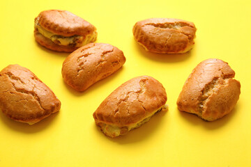 Tasty sochniki with cottage cheese on yellow background