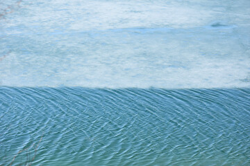 Dreamy rippling blue waves making a pattern and blue clouds