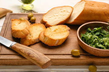 Wooden board of tasty croutons on table