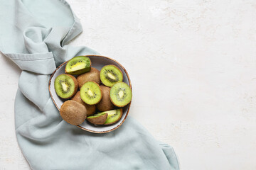 Bowl with fresh cut kiwi on light background