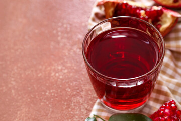 Glass of delicious pomegranate juice on brown background