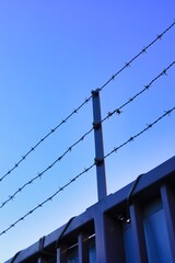 高いフェンスに取り付けられた有刺鉄線