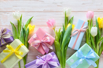 Composition with gift boxes and flowers for International Women's Day celebration on light wooden...