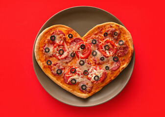 Plate with tasty heart-shaped pizza on red background. Valentine's Day celebration
