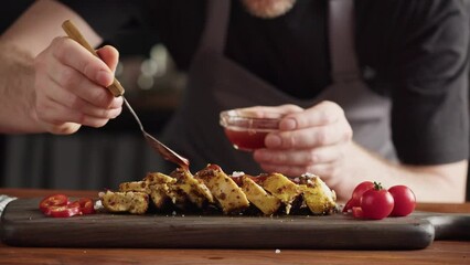 Professional Chef serving chicken breast with salt, meat grill steak with spices, work in a busy kitchen getting ready for service.  - Powered by Adobe
