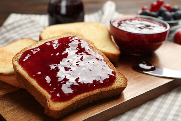 Delicious toasts with jam served on table, closeup
