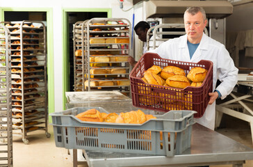 Baker sorts finished products at the bakery. High quality photo