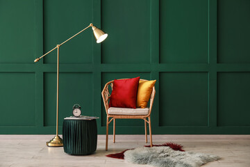 Interior of room with wicker chair and floor lamp near color wall