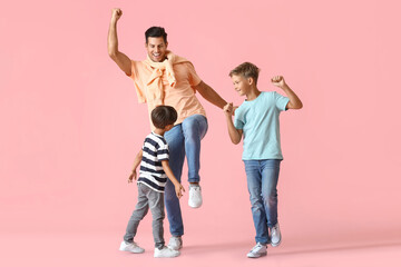 Fototapeta na wymiar Happy dancing man and his sons on color background
