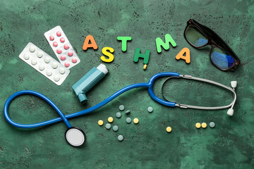 Word ASTHMA, pills, eyeglasses, inhaler and stethoscope on color background