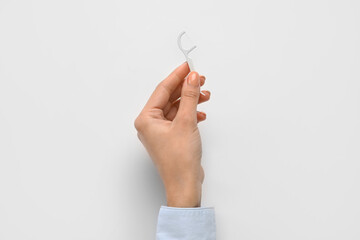 Woman with floss toothpick on white background