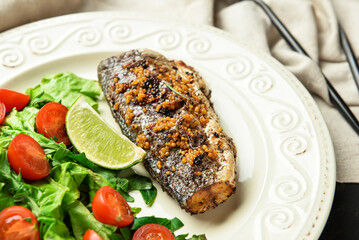 Plate with delicious sea bass fish, vegetables and greens, closeup
