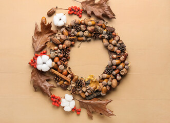 Wreath made of beautiful autumn decor and cotton flowers on color wooden background
