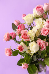 Bouquet of beautiful roses on purple background