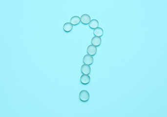 Question mark made of glass stones on color background