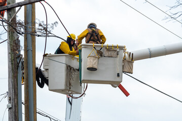 Electricians are climbing on electric poles to install and repair power lines crane service