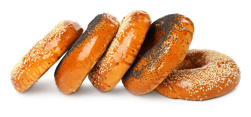 Many delicious fresh bagels on white background