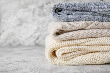 Stylish baby sweaters on light background, closeup