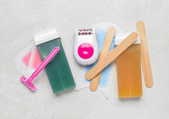 Different supplies for hair removal on light background
