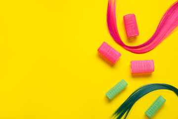 Strands of hair with curlers on color background