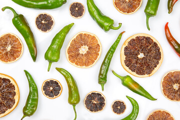 freshly brewed black coffee in a cup on a background of hot green peppers and dried citrus fruit on a white plate. grocery organic flatley
