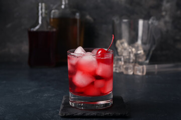 Glass of tasty Manhattan cocktail on black background