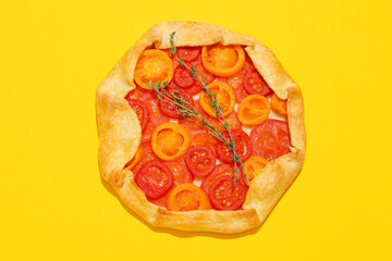 Tasty tomato galette on yellow background