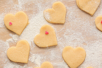 Uncooked heart shaped cookies on wooden background. Valentines Day celebration