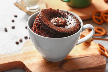 Cup with tasty chocolate brownie on table
