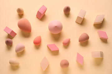 Different makeup sponges on beige background