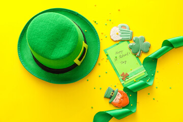 Composition with tasty gingerbread cookies for St. Patrick's Day celebration on yellow background